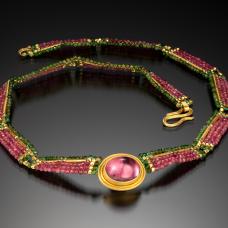Collar  hand woven with pink and green tourmaline  and 20 k gold beads. Bezel  hand fabricated (fused) with 22k gold and set with a brilliant pink tourmaline cabochon. 