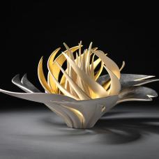 Porcelain that has been carved. Interior is gold gilded.