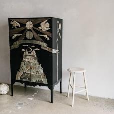 Rosehill Cabinet  Ebonized Walnut case Blackened Steel base birds of prey  mountain  revolvers  and sun motifs hammered silver sunflowers on sides hammered silver  reclaimed aluminum  oxidized copper  carved details wraparound sculptural banner with reclaimed aluminum