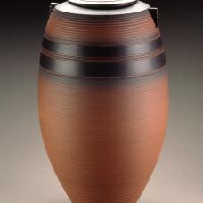 Thrown brown terracotta pot with black accents, lid, and small triangular handles.