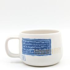 White mug accented with gold dots and blue persian writing. 