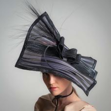 The base square piece of this hat is a natural fiber called Buntal. I cut it into a 16 inch square  and stitched wire at the edge  then stitching Swiss Raffia braid over the both sides of the wire. The center strip and the half crown base I created from 11 mm horsehair braid and accented.