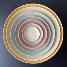 Set of nesting bowls, each with a different glaze color, making up a pastel rainbow