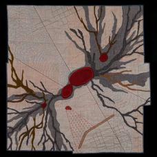 appliqued and quilted aeriel view of a volcano with various map survey details such as elevation markers