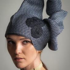 This hat I stitched from one strand of 5 mm wide Swiss braid called Rio. It is a 6 color subtle tweed. Using my hands to shape  I stitched starting as flared tube  then narrowed the tube for many inches until flared back into crown shape. The accent is Swiss Raffia circles.