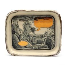 cermic tray with illustration of a man driving and speaking on the phone. The speech bubbles are empty and blocked out with gold.