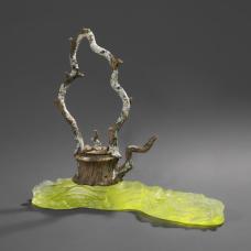 Hand-carved ceramic trompe l'oeil teapot on cast glass stand.