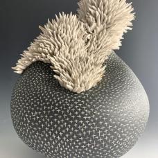 Porcelain vessel with carved crosses topped with clusters of sea anenome-like tenticles with accents of  gold luster