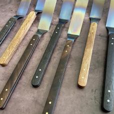 Titanium offset spatula with a variety of wood scales and brass or stainless pins.