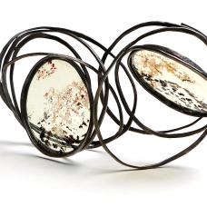 One of a Kind Brooch A chain is made of forged bronze wire. The chain is manipulated to create a 3 dimensional structure showing the union and rhythm of variation. Stove mica is set to highlight the forms and self.