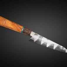 A kitchen Petty (utility knife) in San Mai construction. Blade is diffusion bonded with a 1095 high carbon core and 304 stainless on the sides. The handle is Greater Rhododendron with a Turkish Walnut bolster and a surf stone accent.