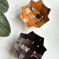 Woven leather bowls are hand-stitched with waxed thread and contrast a single splatter-dyed strip with smooth Buttero vegetable-tanned leather. Each strip is beveled and burnished. The dark brown color has stained edges.