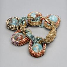 Bracelet with magnetic closure part of the collection Pods. handwoven with fine 24K gold plated and Toho duracoat seed beads. Vintage marbled lucite spheres are nestled in the bead mesh in place of gems. Ongoing collection  limited edition available in various color combinations.