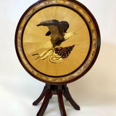 A stunning marquetry image of a bald eagle adorns this tip table. The tabletop is made from hand-cut wood pieces in natural colors with no stains or dyes used. (purpleheart  spalted maple  hemlock  and a variety of natural woods create the image)