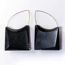 Hand Shaped and polished African Black Wood with Argentium Silver details and ear wires. A locking system is employed to bond the metal and wood. A keyhole system is drilled within the wood and the metal is knurled before epoxying wood and metal together.