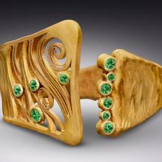 gold cuff with small green stones