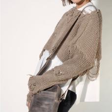 model with leather purse and short distressed sweater